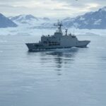 Paisagem ártica da Groenlândia com navios e aviões da OTAN em exercícios militares.