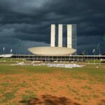 Esplanada dos Ministérios em Brasília com marcas de raio e itens de manifestação sob céu nublado.