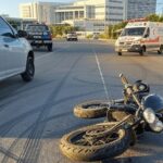 Cena de atropelamento na Avenida do Hospital no Gama, com motocicleta caída e veículos de emergência.