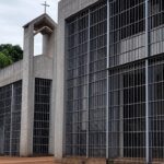 Penitenciária brasileira com capela religiosa ao fundo, representando pedido por assistência espiritual na prisão.