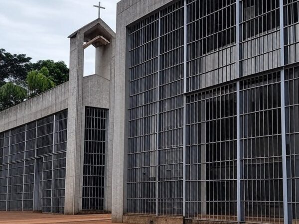 Penitenciária brasileira com capela religiosa ao fundo, representando pedido por assistência espiritual na prisão.