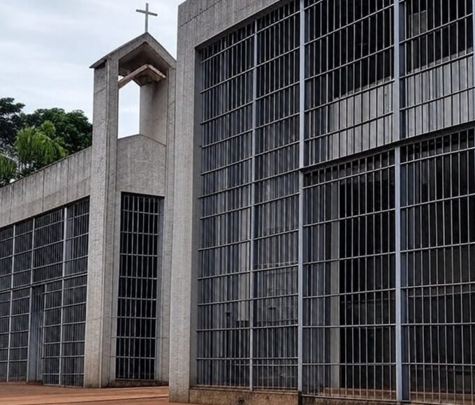 Penitenciária brasileira com capela religiosa ao fundo, representando pedido por assistência espiritual na prisão.