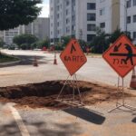 Rua na Asa Norte com tubulações expostas para manutenção no abastecimento de água em Brasília.