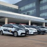 Fachada de hospital em Brasília com viaturas policiais durante investigação de mortes suspeitas.