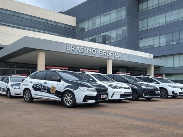Fachada de hospital em Brasília com viaturas policiais durante investigação de mortes suspeitas.