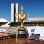 Troféu de ouro da Olimpíada de Educação Financeira sobre mesa com livros e gráficos, ao fundo Congresso Nacional em Brasília, Distrito Federal.