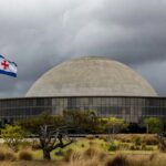 Documentos empoeirados em escritório governamental de Brasília, representando atrasos na regulamentação de lei contra supremacismo no DF.