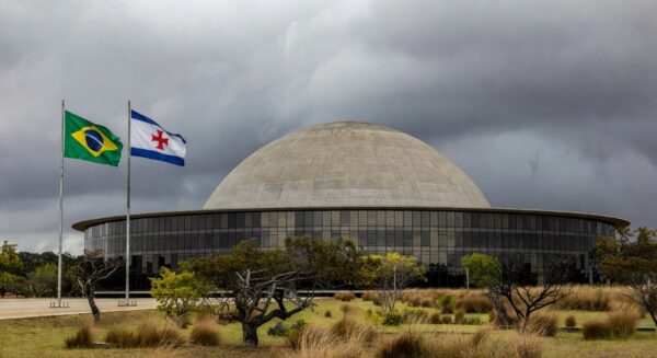 Documentos empoeirados em escritório governamental de Brasília, representando atrasos na regulamentação de lei contra supremacismo no DF.