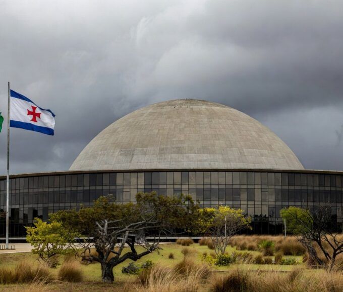 Documentos empoeirados em escritório governamental de Brasília, representando atrasos na regulamentação de lei contra supremacismo no DF.