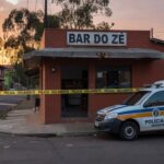 Cena de bar no Gama com fita de isolamento policial e viatura da PMDF após assassinato por discussão em conta.