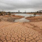 Infraestrutura de saneamento negligenciada em Brasília, com tubulações antigas expostas, representando anos de descaso no DF.