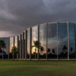 Fachada da CLDF em Brasília com documentos simbolizando escrutínio no BRB por falta de transparência e irregularidades.