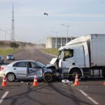 Avenida movimentada em Brasília com veículos e sinalização de trânsito, ilustrando aumento de mortes no tráfego.