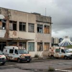 Hospital público e viaturas policiais em Brasília, representando crise no sistema de saúde e segurança no DF.