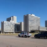 Vista dos setores hoteleiros em Brasília com viaturas policiais e câmeras de segurança, representando ampliação da Área de Segurança Especial.