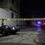 Cena de rua em Taguatinga, DF, com motocicleta abandonada e marcas de tiros, indicativa de crime violento.