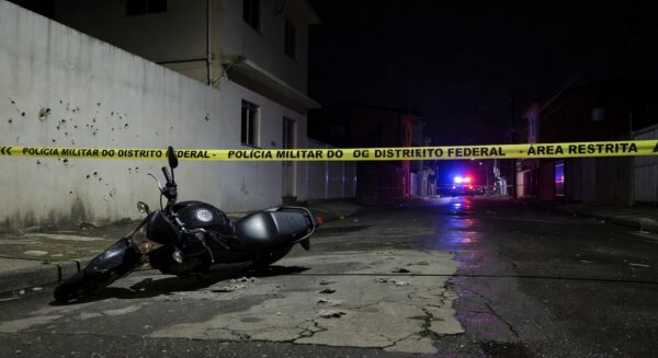 Cena de rua em Taguatinga, DF, com motocicleta abandonada e marcas de tiros, indicativa de crime violento.