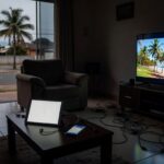 Pilha de smartphones e tablets em mesa de casa brasileira, representando riscos do uso excessivo de telas para jovens.