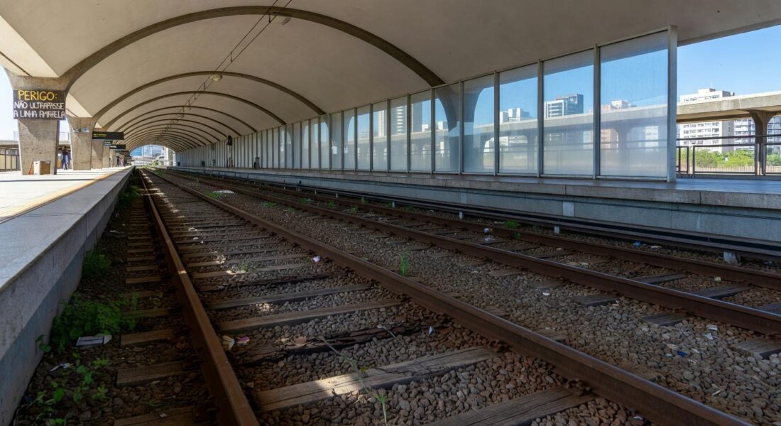 Estação de metrô em Brasília com documentos espalhados, representando ineficiências em aquisições públicas do Metrô-DF.