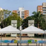 Praça no Gama com tendas para ação comunitária do GDF oferecendo serviços gratuitos.