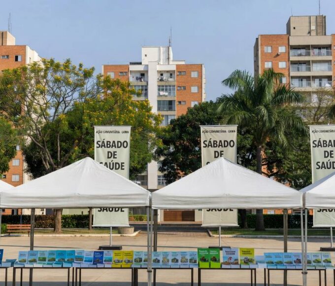 Praça no Gama com tendas para ação comunitária do GDF oferecendo serviços gratuitos.