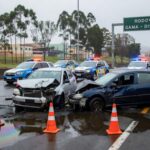 Cena de colisão na DF-483 com veículos danificados e derramamento de óleo no Gama, Distrito Federal.