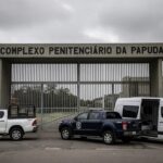 Entrada do Complexo Penitenciário da Papuda com viaturas da Polícia Federal, representando Operação Compliance Zero e prisão de ex-presidente do BRB.