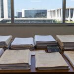 Mesa com documentos de aposentadoria de professores no TJDFT em Brasília, representando acordo administrativo com PGDF.