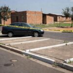 Rua em Samambaia com vagas de estacionamento e viatura policial, representando briga por vaga que levou a assassinato.