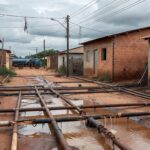 Tubulações expostas e ligações clandestinas em rua do Riacho Fundo II, com equipamentos da Caesb, destacando ação do GDF contra irregularidades.