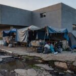 Rua em Brasília com barracos improvisados, representando projeto de lei sobre internação compulsória de moradores de rua no DF.